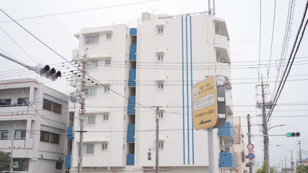 古我知さんが避難協定を結んだ民間の共同住宅。手前には津波避難場所の標識が立つ