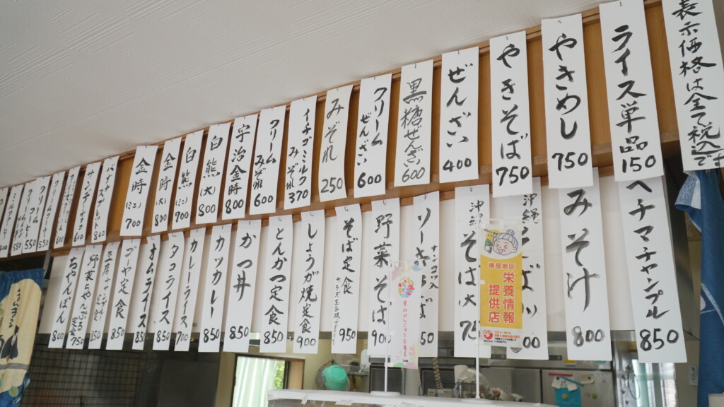 店内の壁にずらりと並んだ手書きの短冊メニュー。『白熊』『金時』などの冷やしものから食事メニューが並ぶ