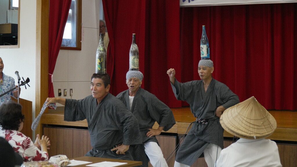 頭に酒瓶を載せて舞う瓶踊りのメンバー3人