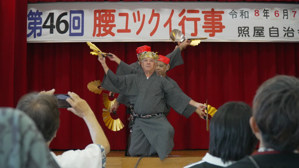 赤い冠をつけ金の扇子を広げる四季口説の一場面(千手観音)